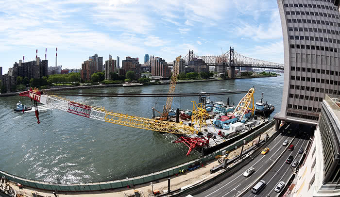 Ready to lift: The barge-mounted crane that will lift the prefabricated modules of the River Campus into place over FDR Drive arrives at Rockefeller. 