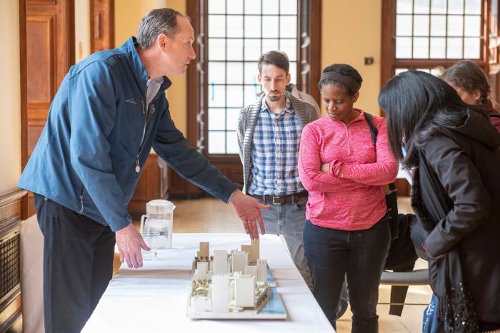 Timothy P. O'Connor, the university’s executive vice president, shows a model of the river campus.