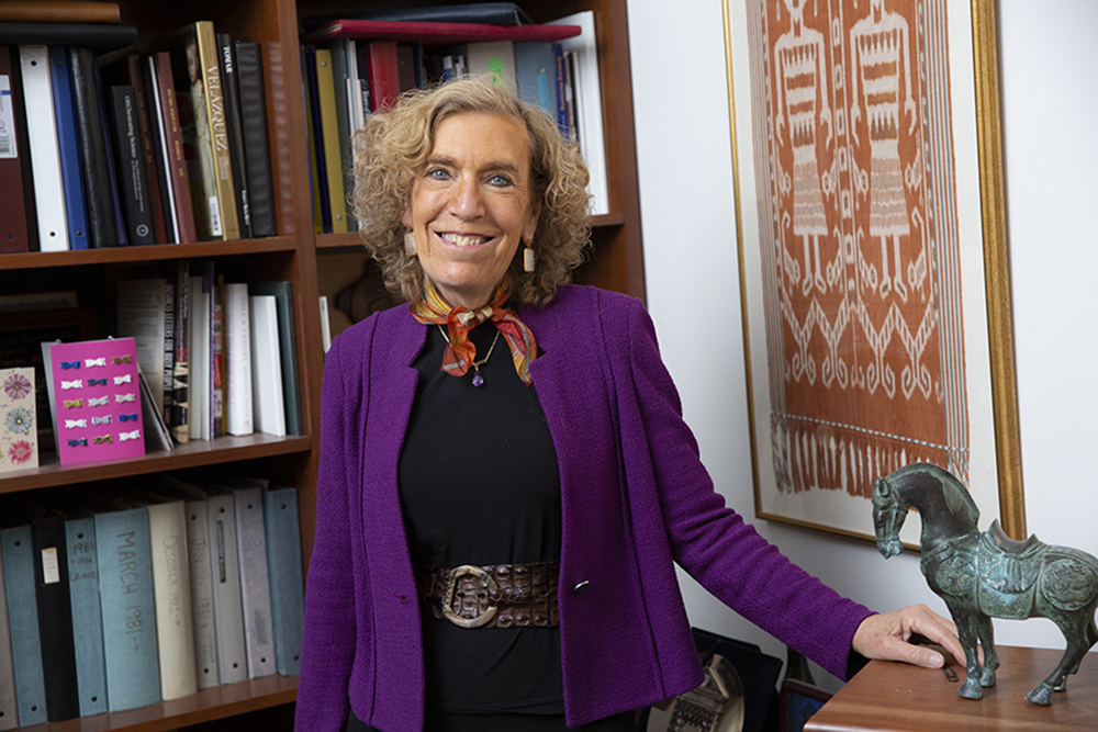 Elaine Fuchs standing in front of bookcase in office