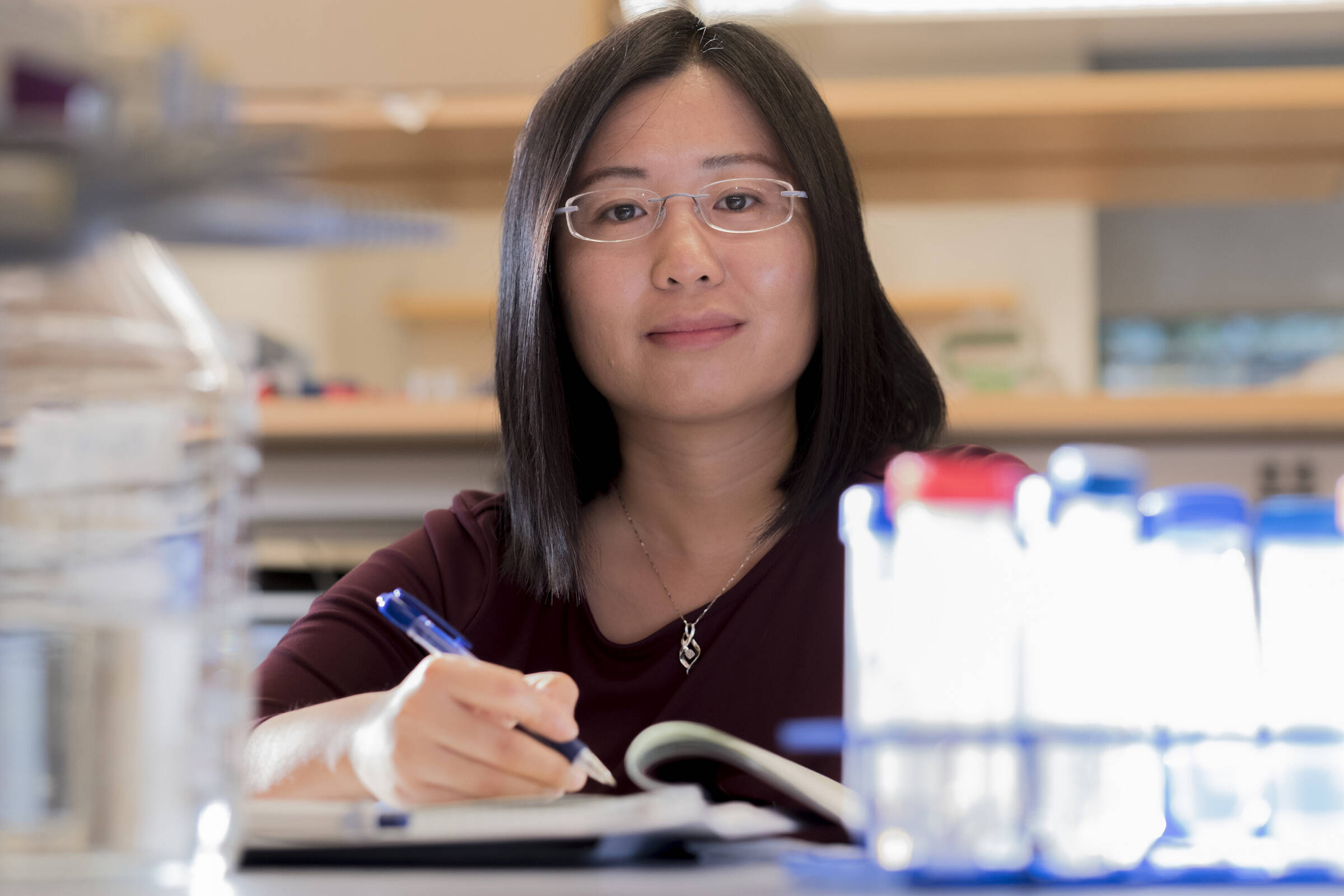 Rockefeller University's Li Zhao holding a pen in her lab