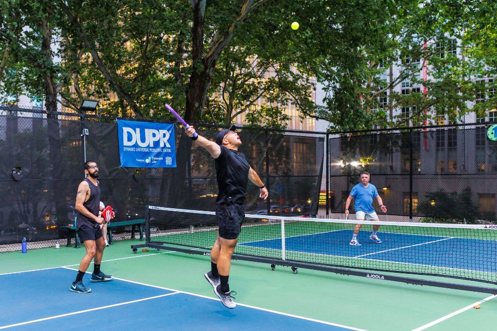 Mark Gad, Daniel Oh, and Alex Kogan play pickleball on a green and blue court