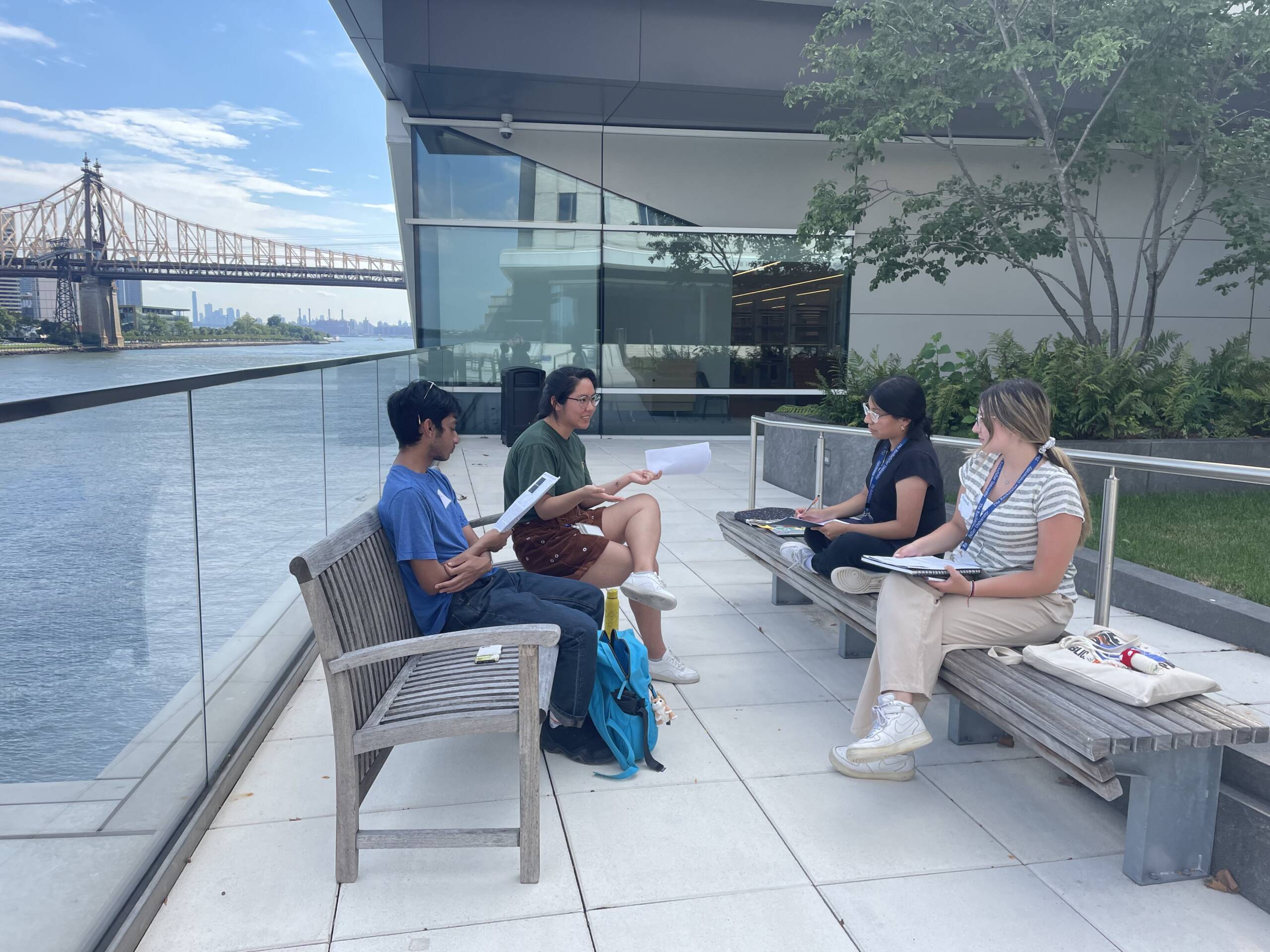 A mentor and three students in a journal club discussion outdoors.