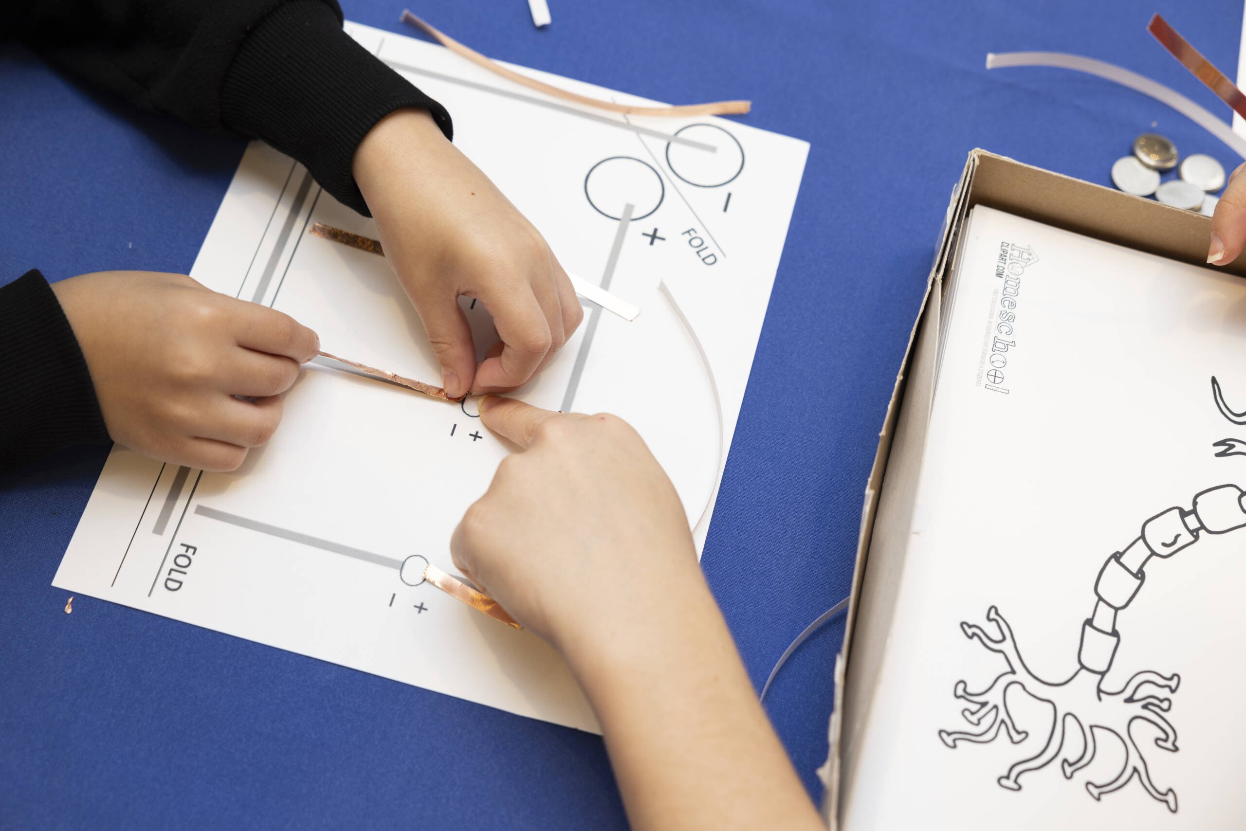 Kids built their own neuron with copper strips, LEDs, and penny batteries.