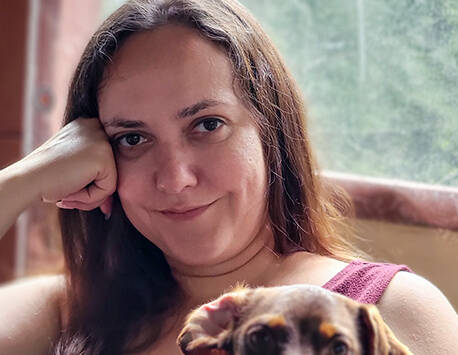 Inna Piscitello sitting on a couch with a dog