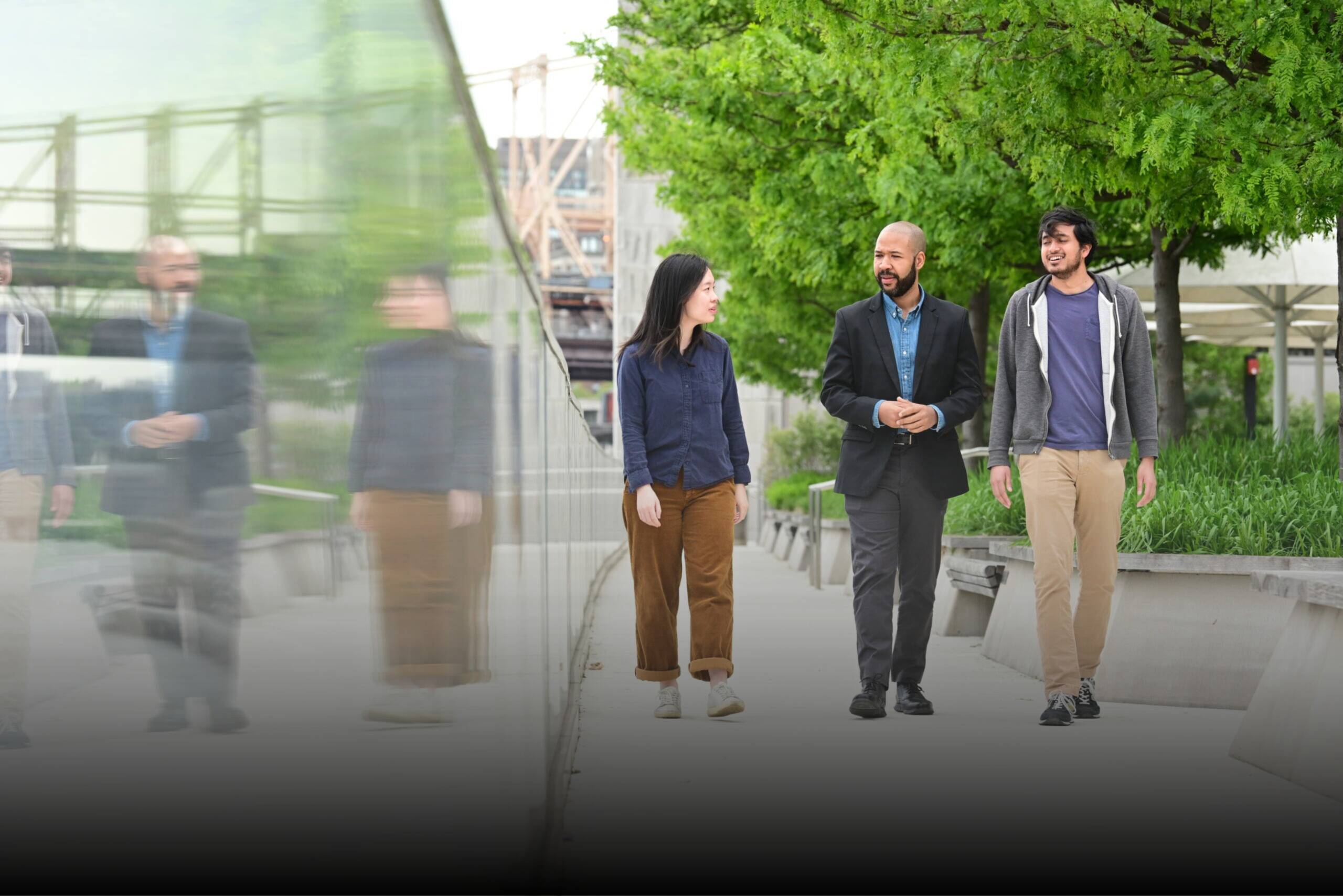 three community members walking on a campus sidewalk